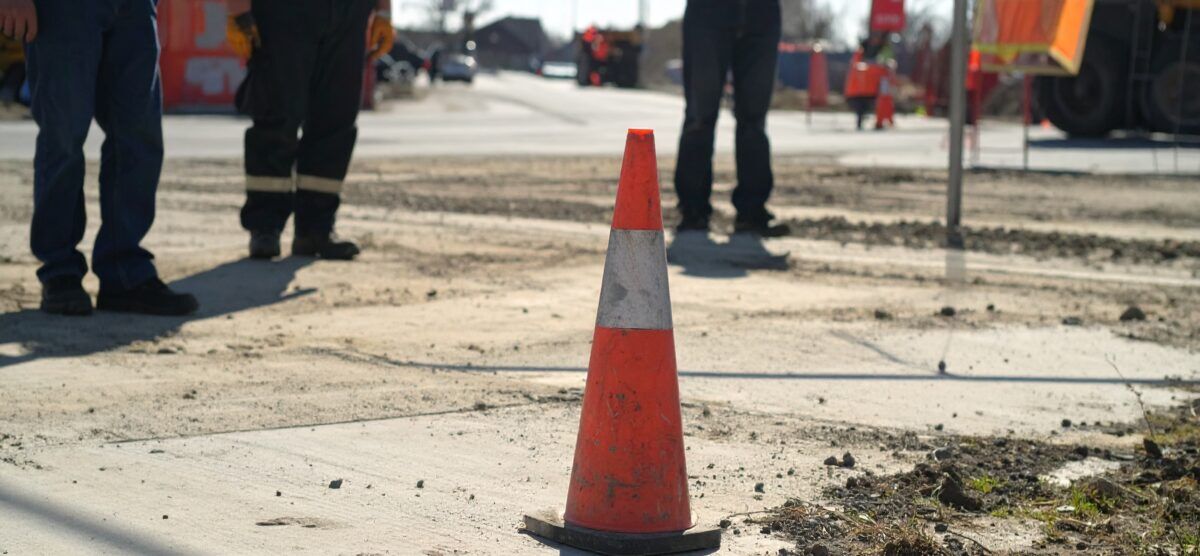 Safety cone marking a danger zone to pause work and protect crews in active road construction.