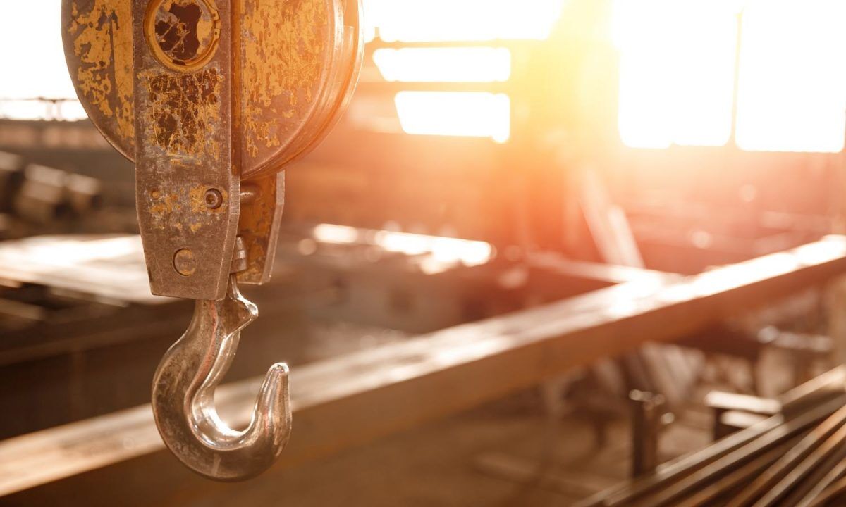 Industrial overhead beam crane lift background factory sunlight.