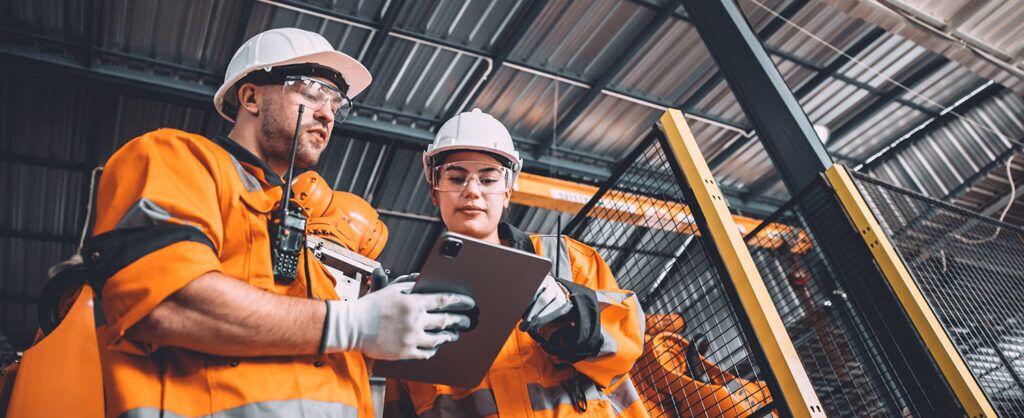 Engineer team service robot welding working in automation factory. People worker in safety suit work robotic arm software programming or replacing part in automated manufacturing industry technology.