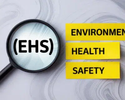 Magnifying glass showing EHS with yellow Environment, Health, and Safety labels.