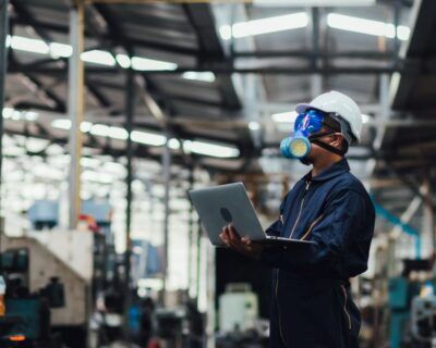 Officials from the Department of Hazardous substances control bureau is investigating the leak of a hazardous chemical in a chemical plant. Man with protective mask and computer laptops in factory