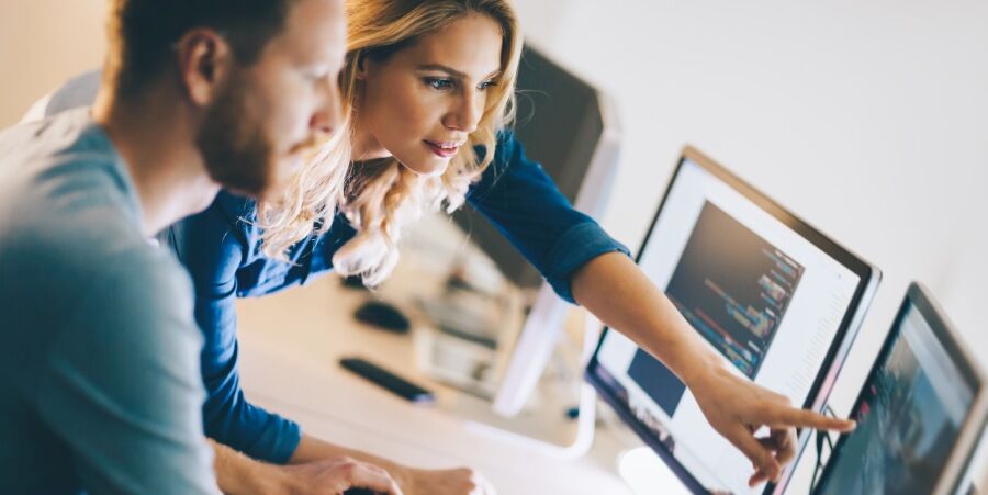 Attractive man and woman working with HR tools at work in a well lit office.