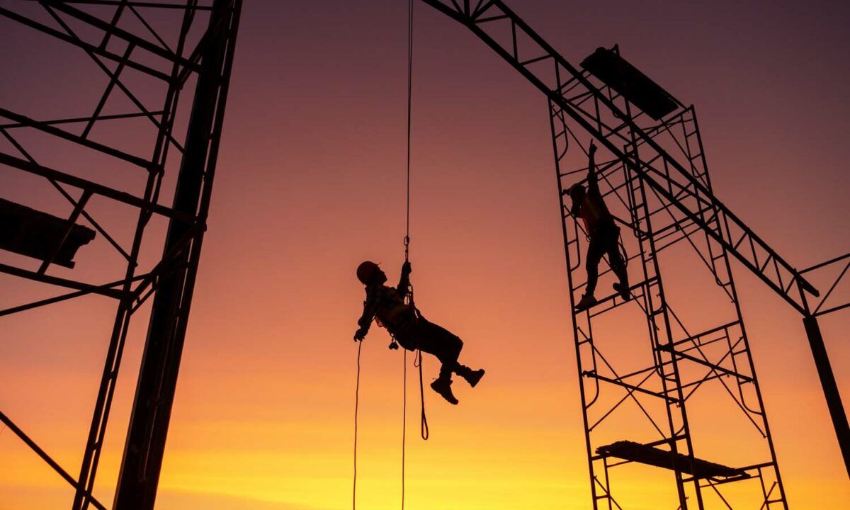 Male working abseiling on a construction site silhouette worker
