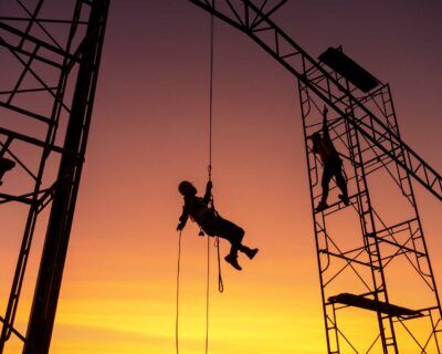Male working abseiling on a construction site silhouette worker