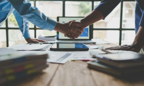 Young businessman and financial representative shaking hands after a budget deal for business expansion and investment in a village construction project real estate financial concept. Young businessman and financial representative shaking hands after a budget deal for business expansion and investment in a village construction project real estate financial concept.