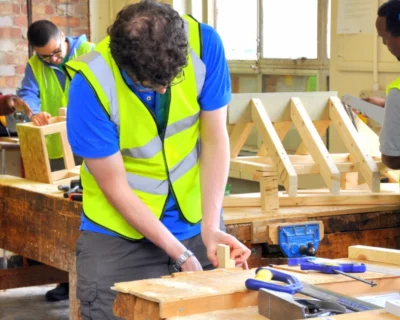 Workers in safety vests at carpentry table