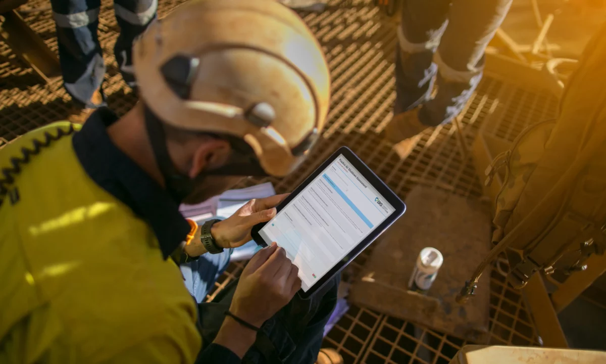 Construction foreman conducting a mobile FLHA using a tablet on the jobsite.