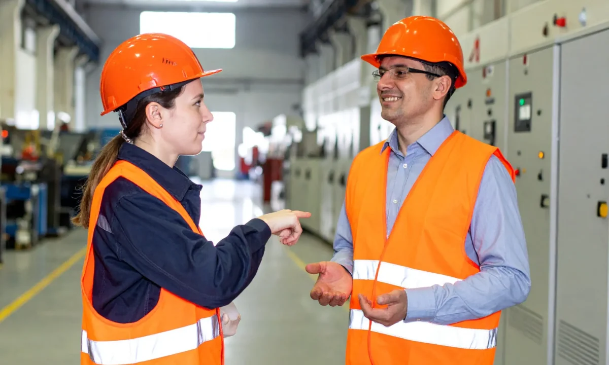 Two workers having an open conversation in a facility, demonstrating trust and psychological safety at work.