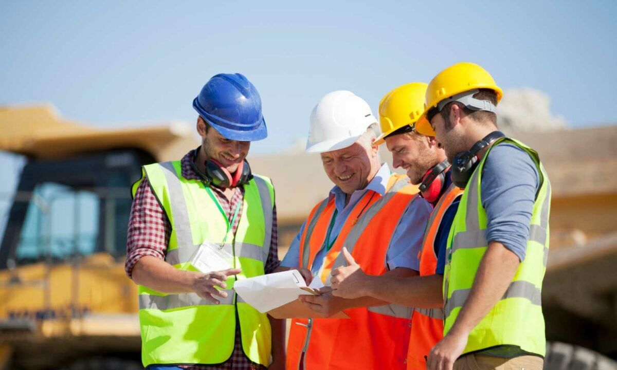 Workers and businessman talking in quarry at toolbox talk