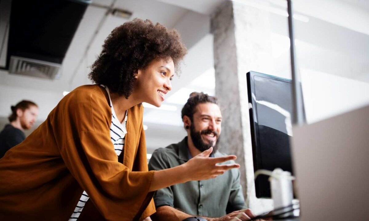 woman describes and teaches coworker how to use HR tool