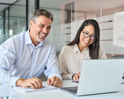 Happy diverse executives team two professional managers looking at Learning management software