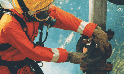 firefighter in an orange suit is working on a pipe