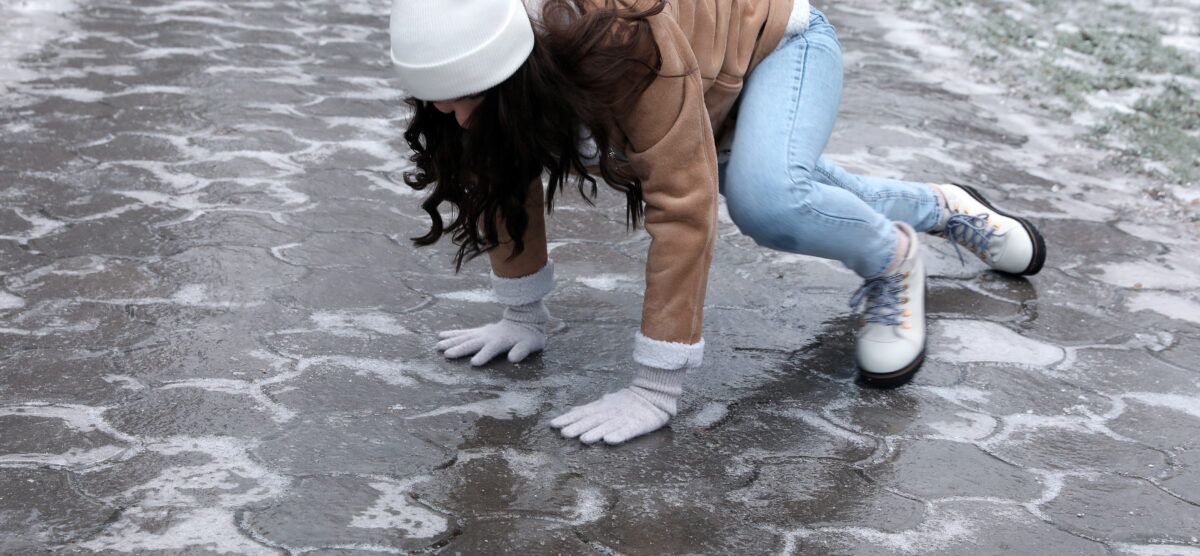 Fall on black ice along a facility path, highlighting the need for traction control and better lighting.