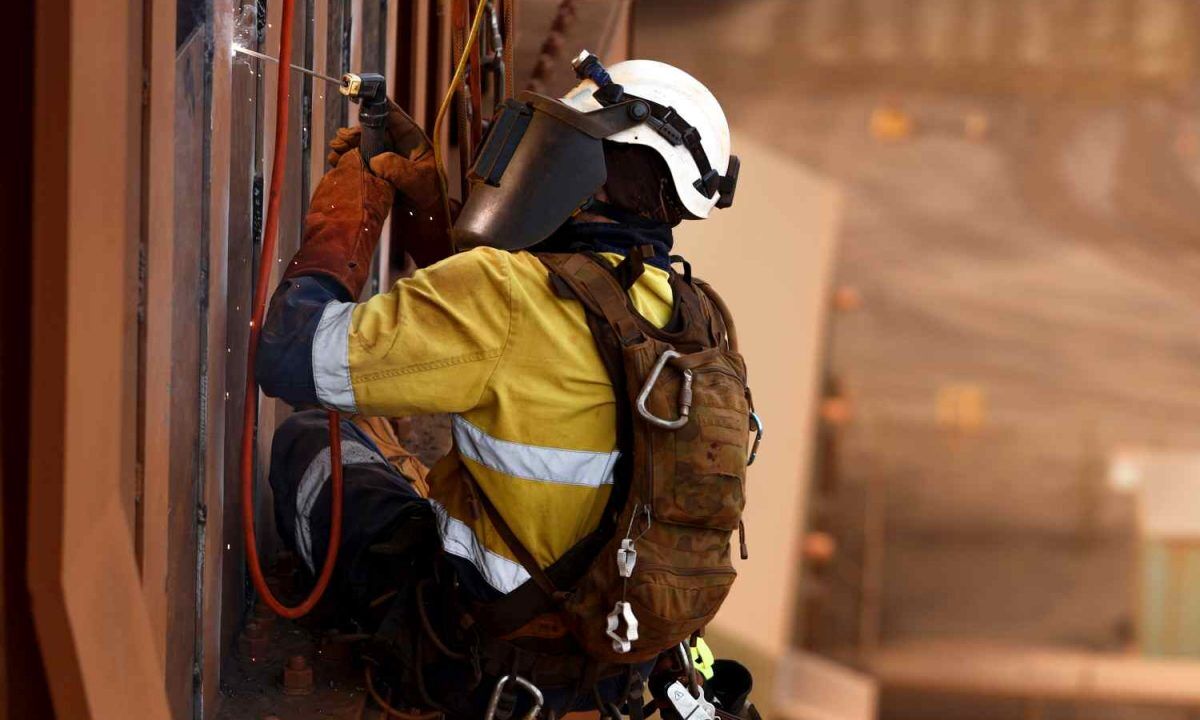 Close up shoot of rope access stick welder wearing full body saf